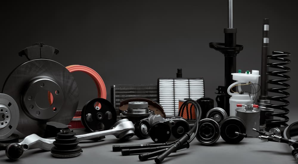 A display of car parts are shown on a grey and black backdrop.