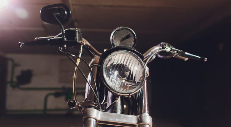 A close up of the headlight and handlebars on a motorcycle is shown.