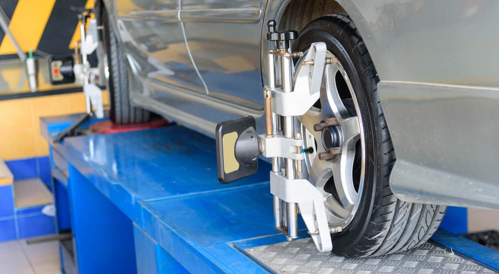 A silver car is shown during an alignment after visiting an auto body shop near you.