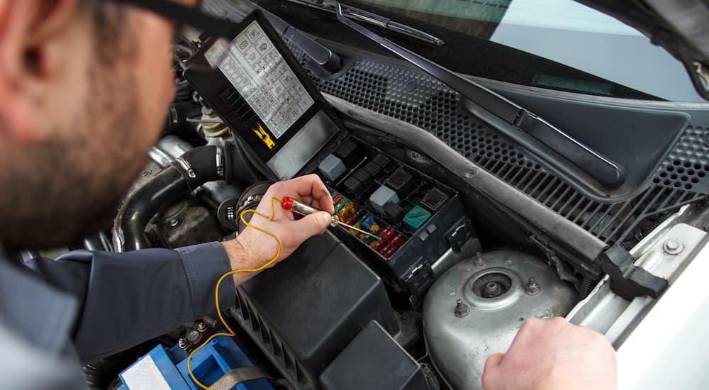 A mechanic is shown testing a fuse during a Honda car repair.