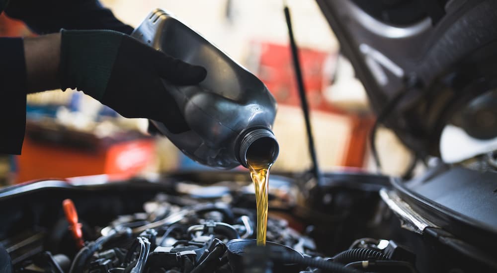Fresh oil is shown being poured into a crankcase during an oil change near you.