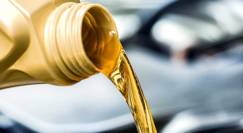 Oil is shown being poured into an engine after an oil change.