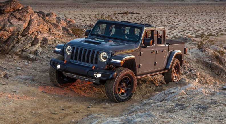 A grey 2021 Jeep Gladiator Mojave is shown from the front after leaving a Jeep service center.