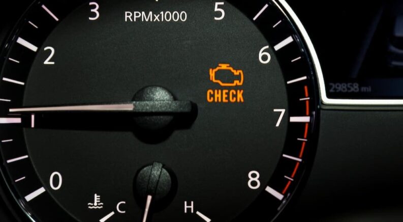 A check engine light is shown on the dash of a vehicle.