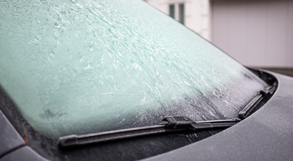 Winter windshield wipers are shown on a frozen windshield.