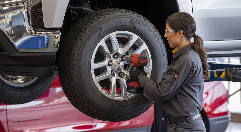 A technician is shown installing an all-season tire on a Chevy Silverado. 