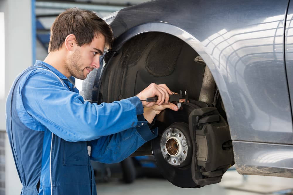 A mechanic is shown performing brake maintenance. 
