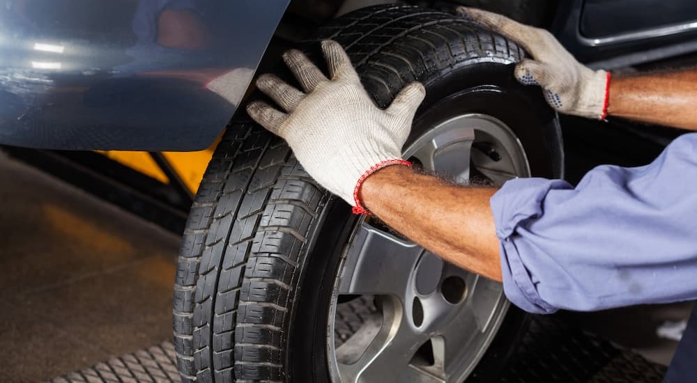 A mechanic is shown replacing a tire.