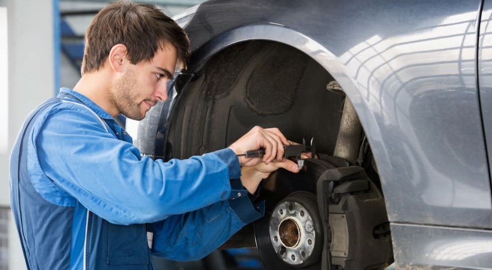 A mechanic is shown performing brake maintenance.