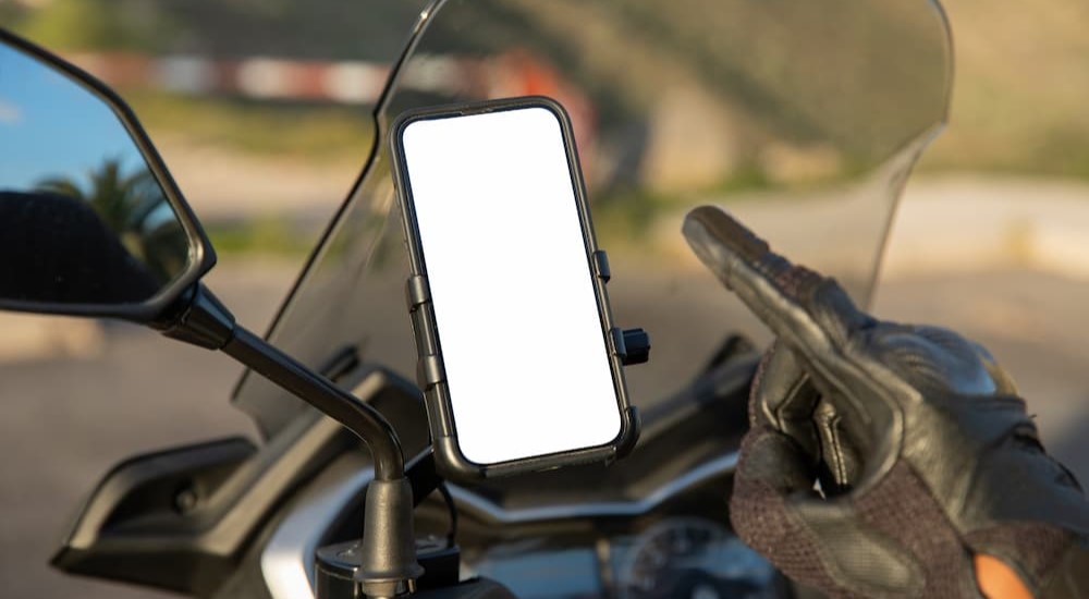 A finger is shown pointing at a cell phone mount.