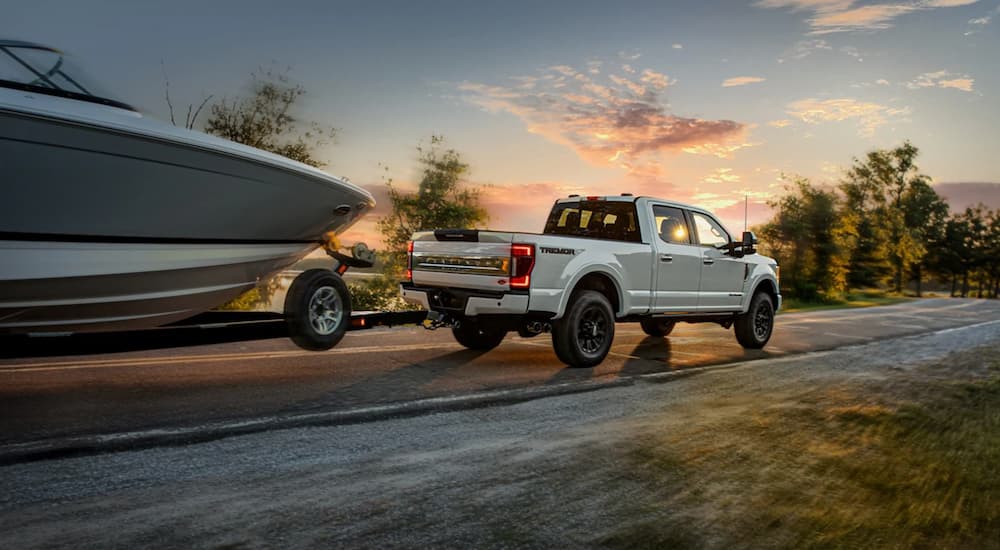 A white 2021 Ford F-250 Super Duty Tremor is shown towing a boat.
