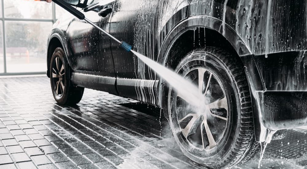 A wheel is shown being sprayed clean with a hose.
