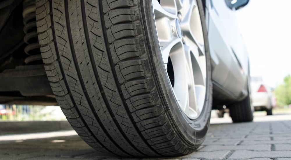 An all season tire is shown on a car.