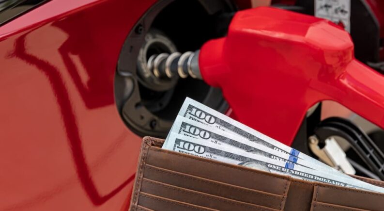 Money in a wallet is shown after saving money at the gas pump.