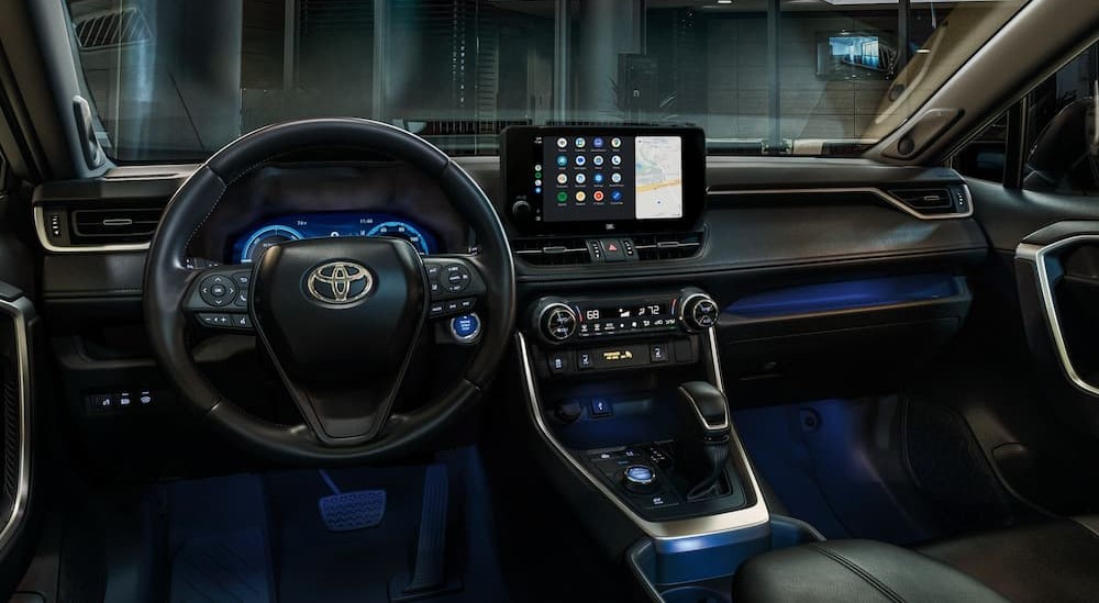 The black interior and dash of a 2024 Toyota RAV4 Hybrid is shown.