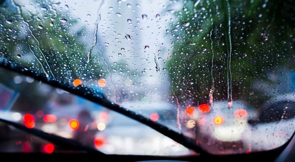 Rain is shown blurring the vision of a driver.