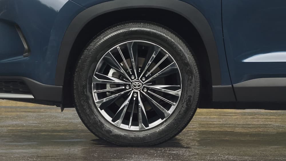 A close-up of the wheel on a blue 2024 Toyota Grand Highlander is shown.