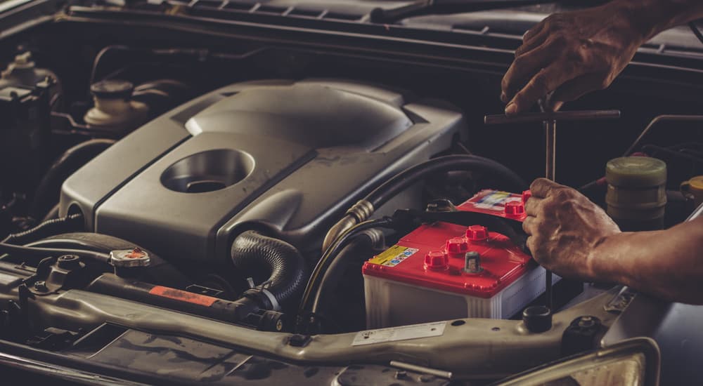 A car battery is shown plugged into an engine.