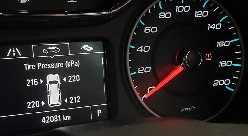 A dash display shows a tire pressure warning.