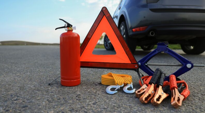 A roadside safety kit is shown near a vehicle.
