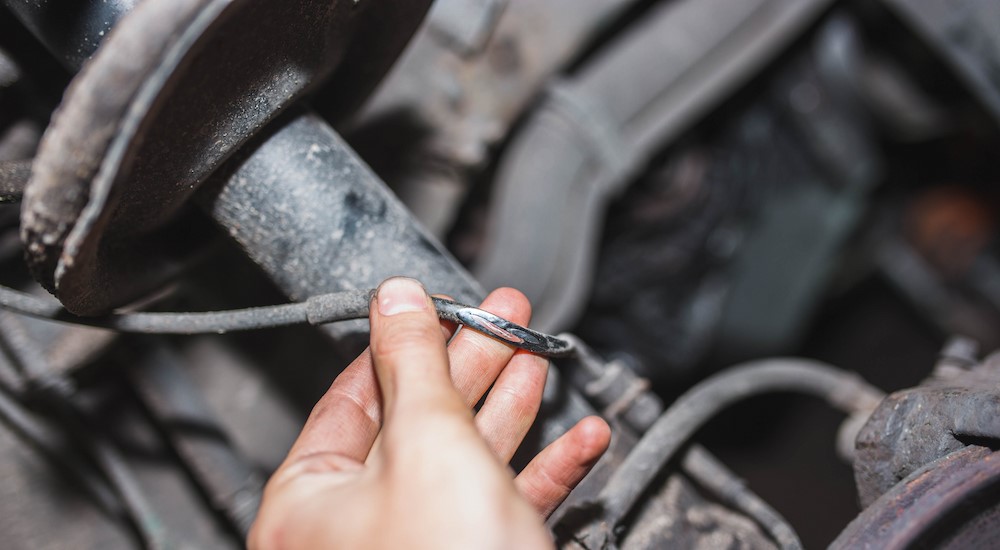 A mechanic is shown holding frayed ABS wires.