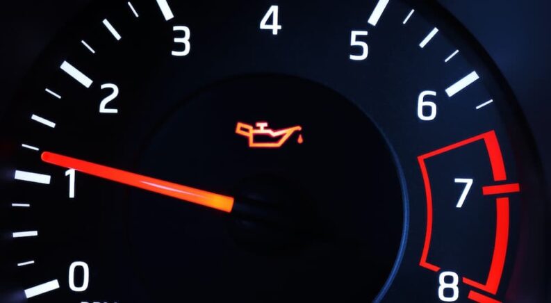 An oil warning light is shown on a dashboard.