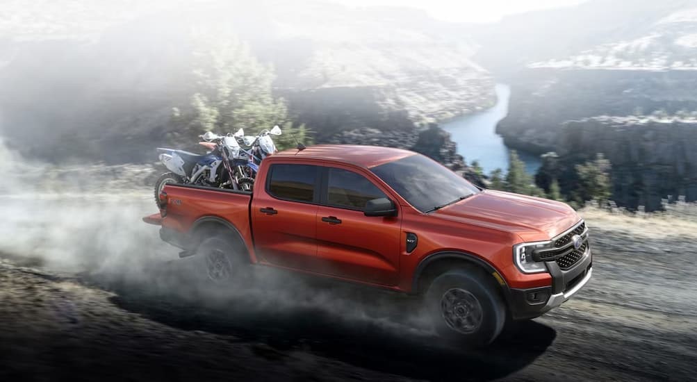A red 2024 Ford Ranger is shown driving off-road above a river.