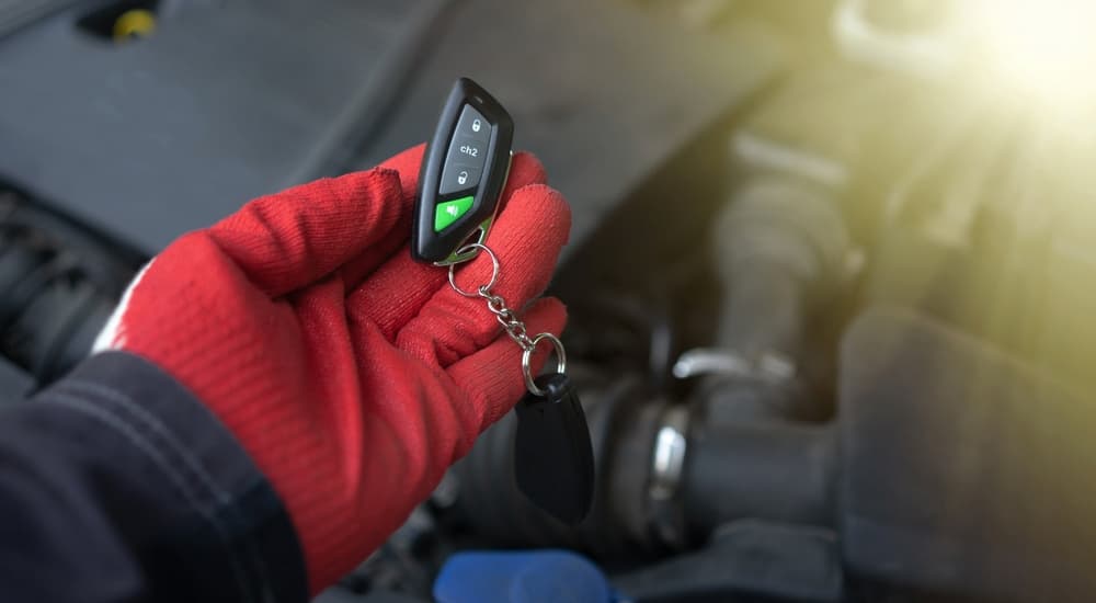 A person wearing a red glove and keyless entry remote.