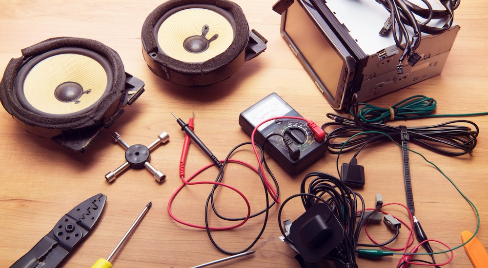 Speakers, touchscreen system and tools for an installation are shown on a table.