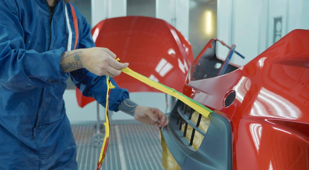 A person is shown removing tape from a vehicle.