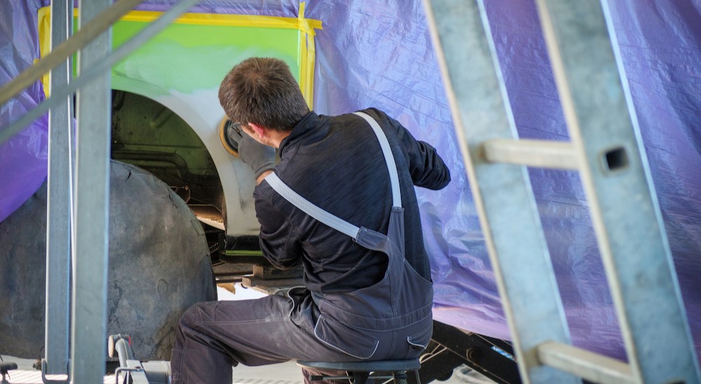 A person is shown buffing a vehicle.