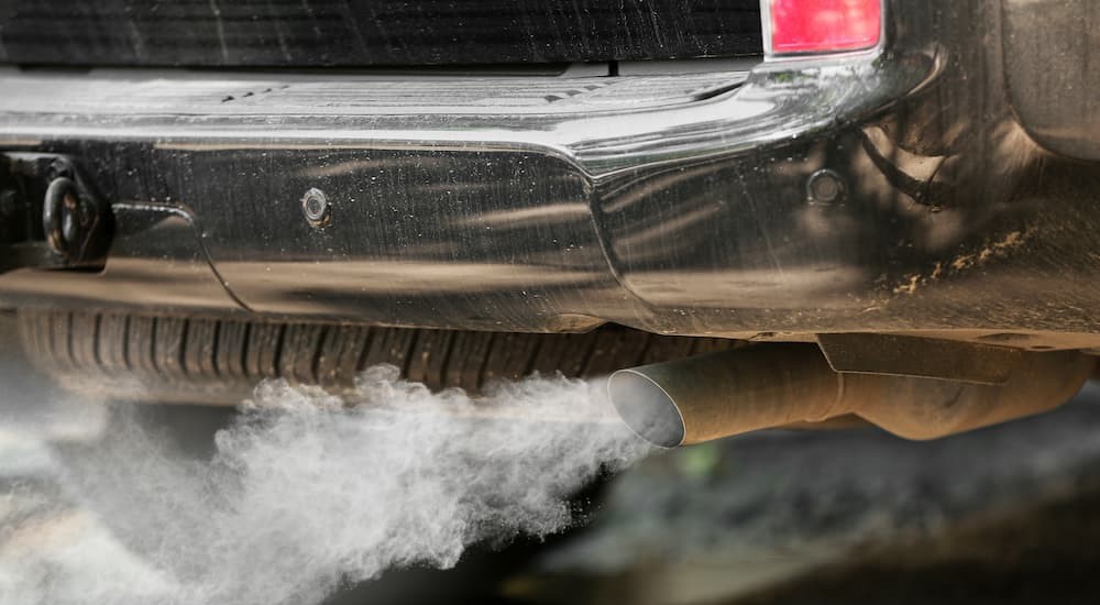 White smoke is shown exiting a vehicle's tailpipe.