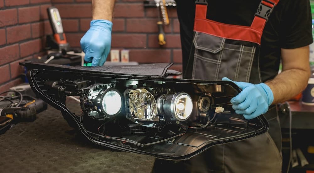 A technician is shown working on a headlight.