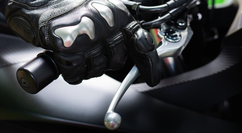 A biker is shown with a finger resting on a brake lever.