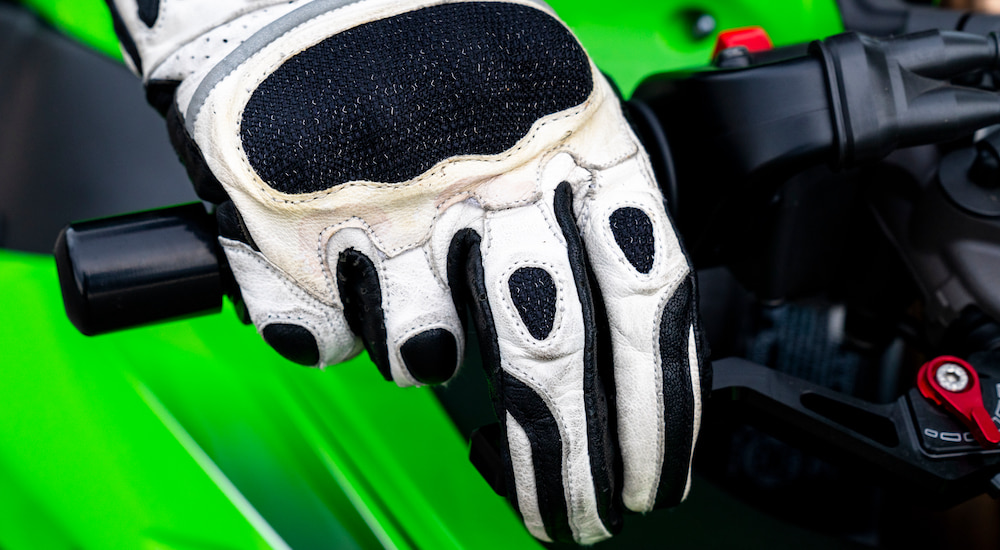 A biker is shown with their hand resting on a shorty brake lever,