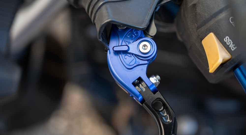 A close-up shows a folding adjustable motorcycle lever.