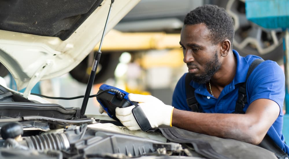 A mechanic is shown performing check engine light diagnostics.