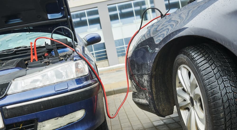 Two vehicles are shown attached by jumper cables.