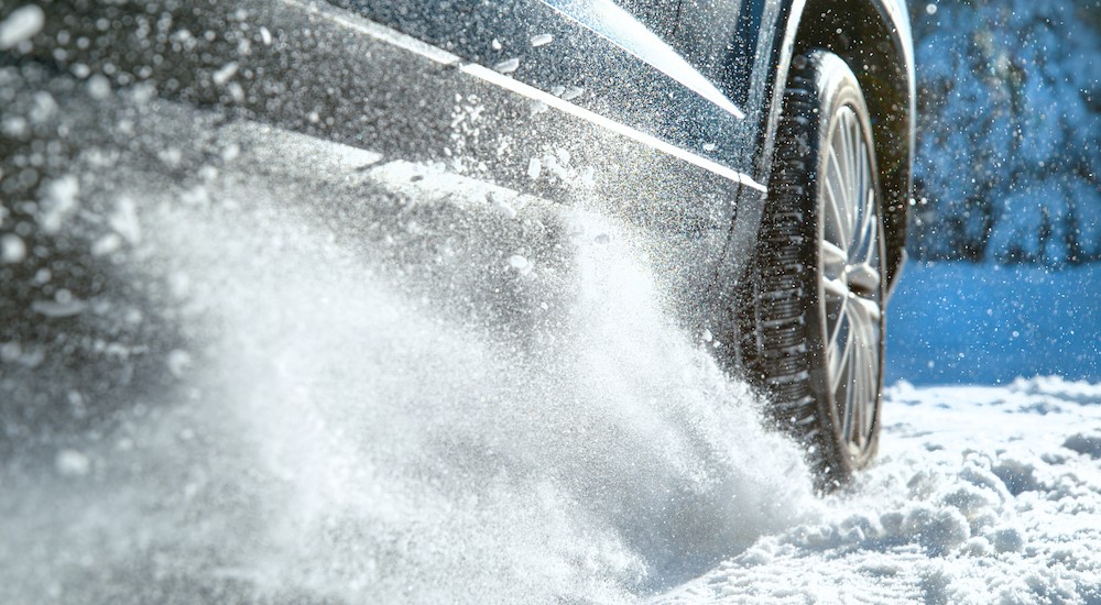 A vehicle is shown driving on a snowy road.