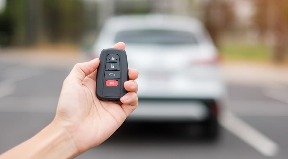 A person is shown holding a key fob