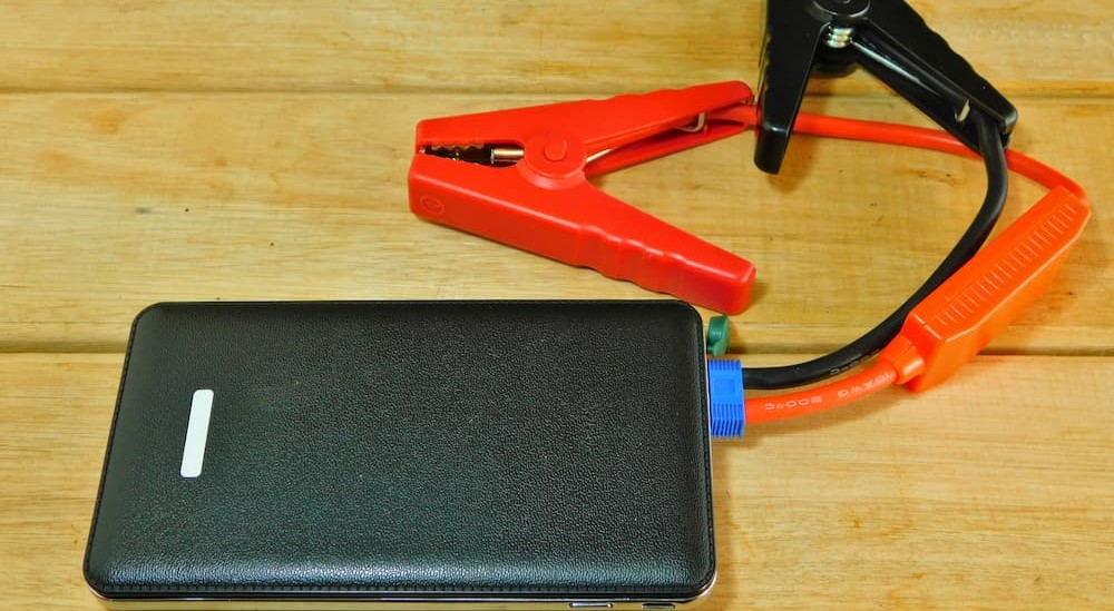 A rechargeable jump pack is shown on a wooden table.