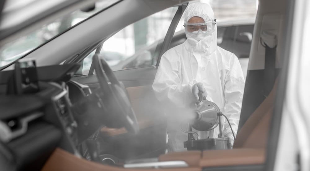 An exterminator is shown fumigating a vehicle with pests.