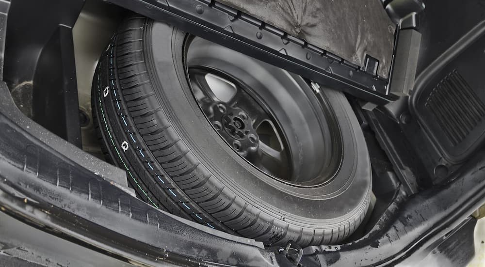 A spare tire is shown in a trunk.