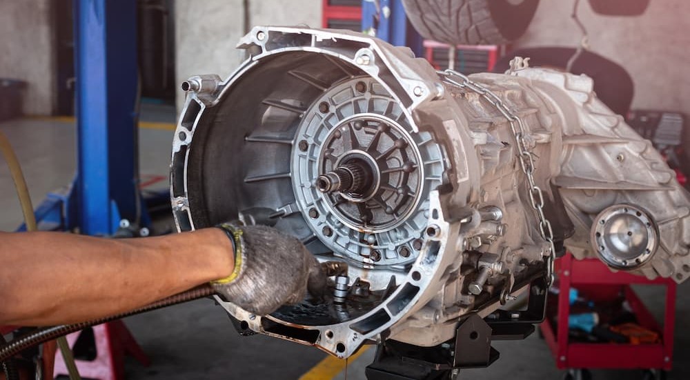 A technician is shown working on an automatic transmission.