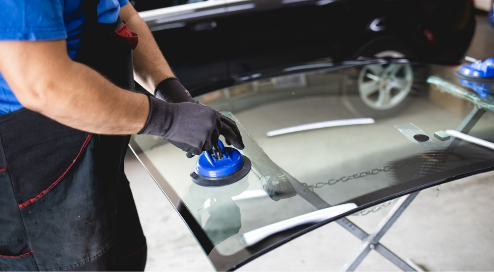 Mechanics are shown replacing a windshield.