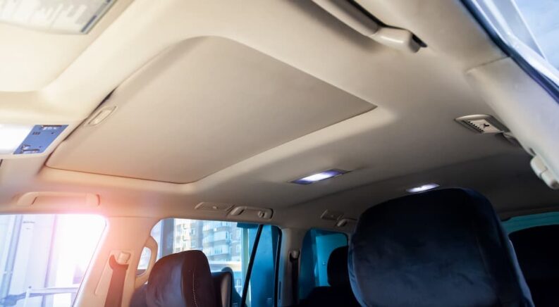 A tan headliner and moonroof in a vehicle