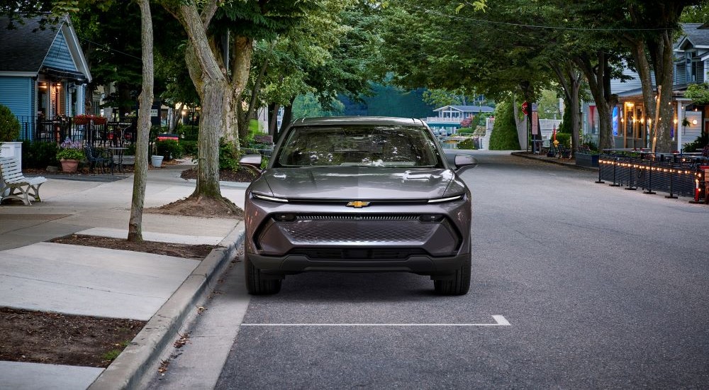 A silver 2025 Chevy Equinox EV 1LT parked in a neighborhood
