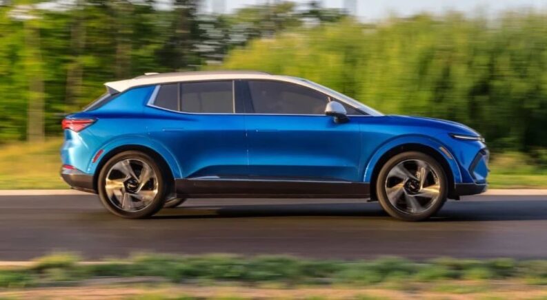 A blue 2025 Chevy Equinox EV driving down a street
