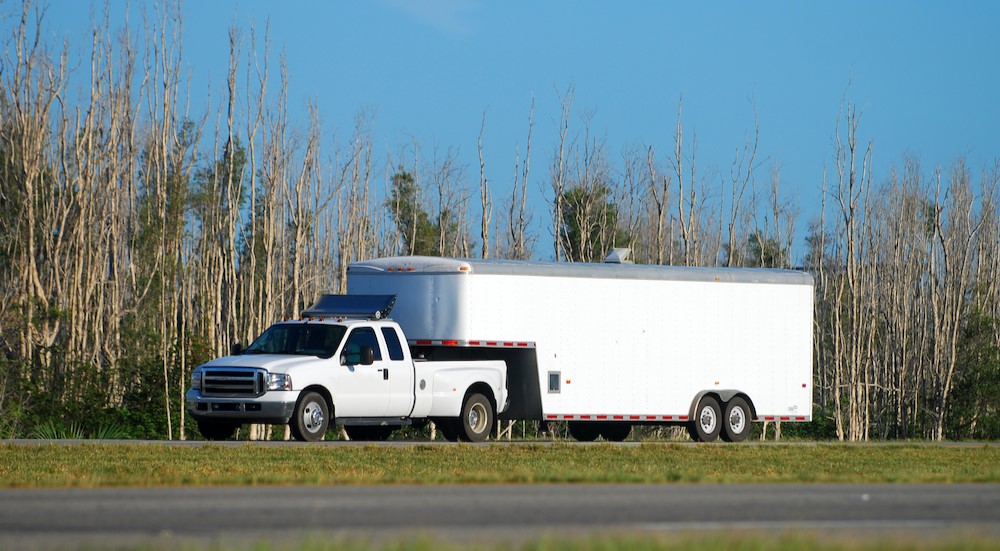 A white truck towing a white trailer.