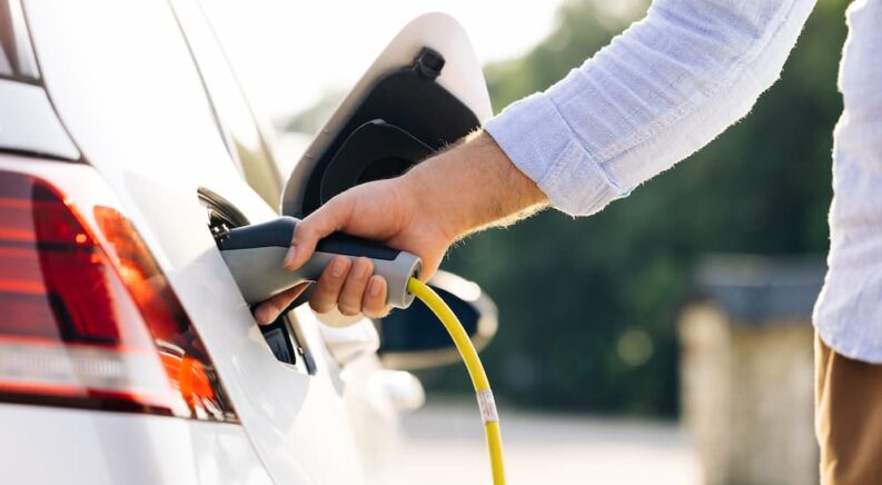 A man plugging in his electric vehicle to charge